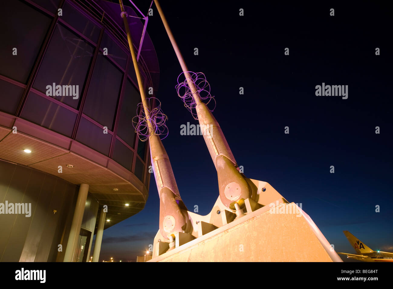 Uno dei tre basamento montanti di supporto appartenente all'aeroporto di Heathrow è di nuovo la torre di controllo di notte sul campo d'aviazione il grembiule. Foto Stock