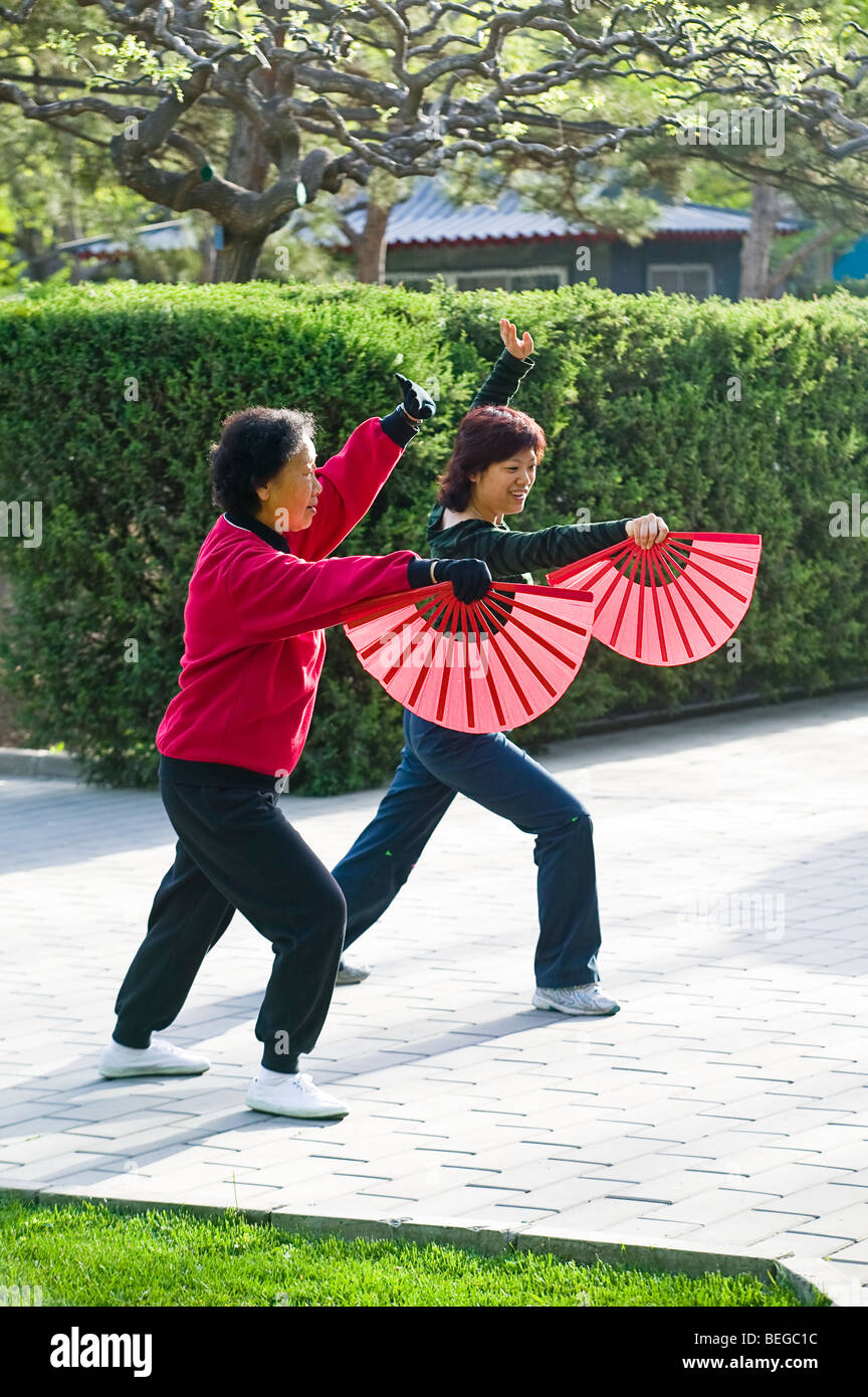 Due donne cinesi esercitano con ventole all'aperto a Pechino in Cina Foto Stock