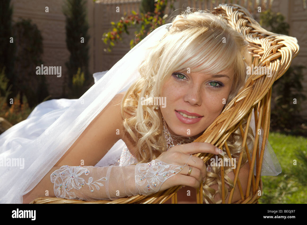 La sposa ha un resto in una poltrona su un prato. Foto Stock