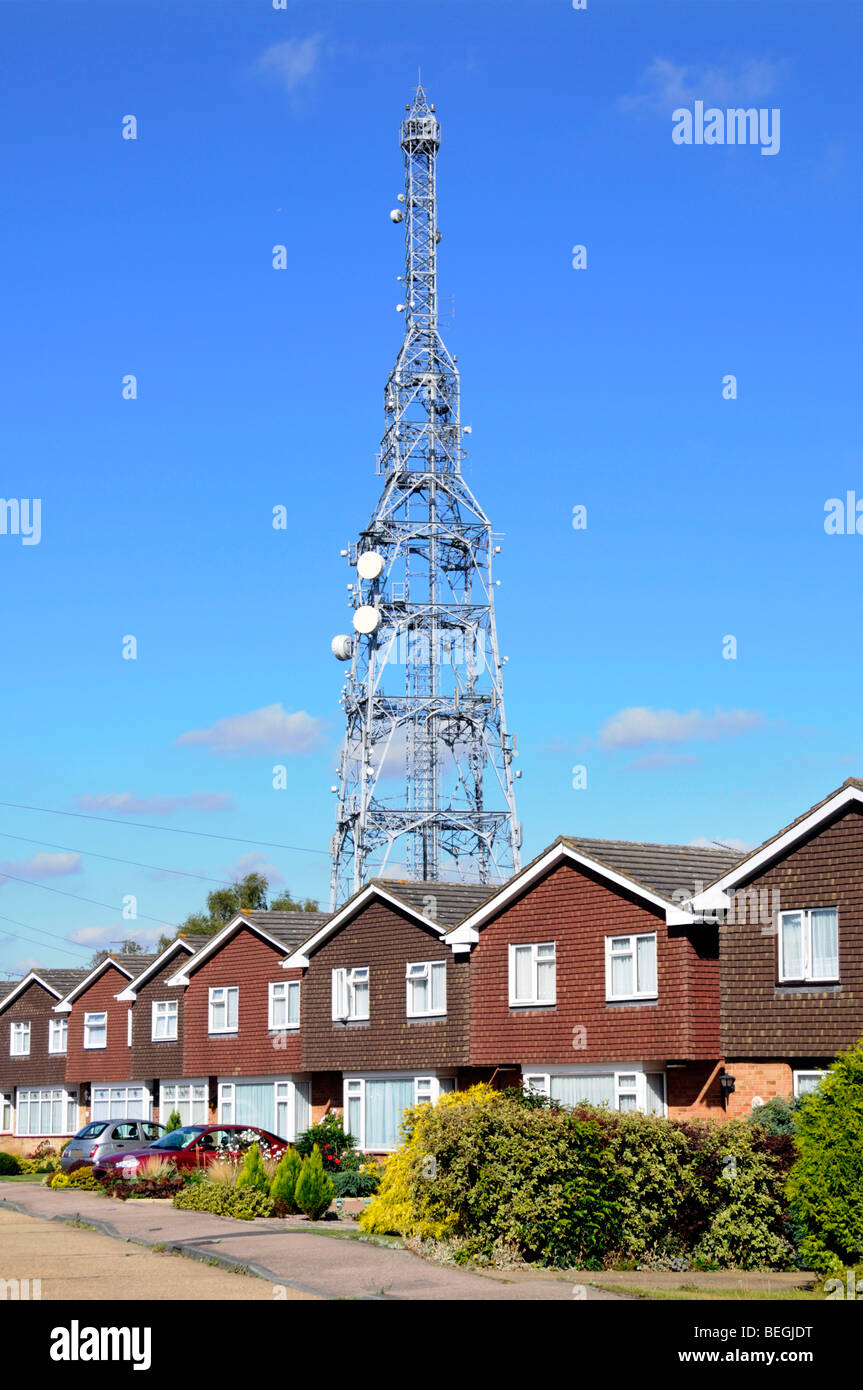 Montante di telecomunicazioni sollevandosi al di sopra di fila di case Foto Stock