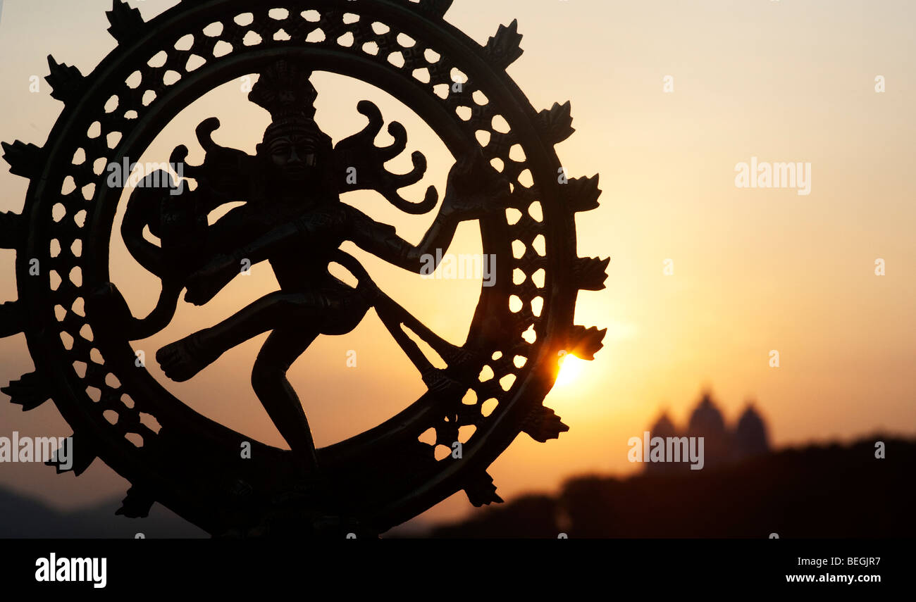 Dancing signore Shiva statua, Nataraja silhouette, contro un tempio indiano sunrise sfondo. Puttaparthi, Andhra Pradesh, India Foto Stock