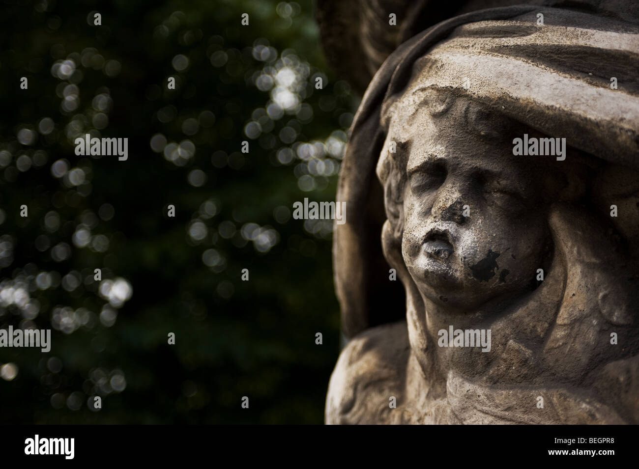 Una scultura in pietra di un cherubino che soffrono di erosione e danni da inquinamento a Londra. Foto Stock