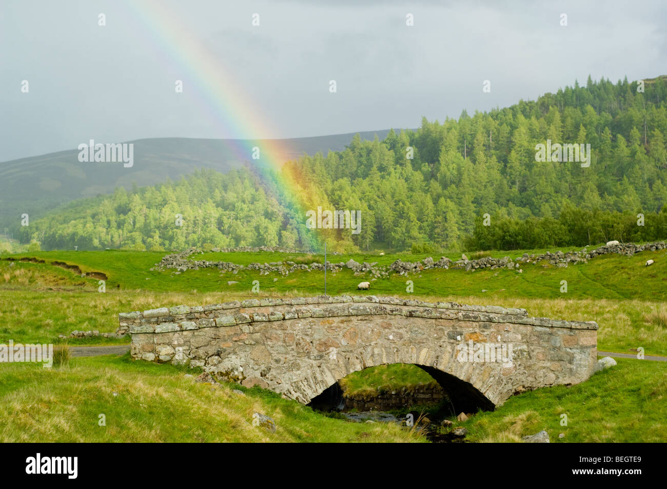 Rainbow in Glen Gairn, al di sopra di un vecchio arcuata di ponte di pietra Foto Stock