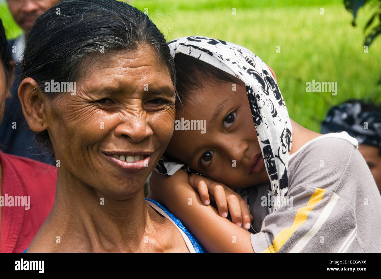 La madre e il bambino a un funerale in Bali Indonesia Foto Stock