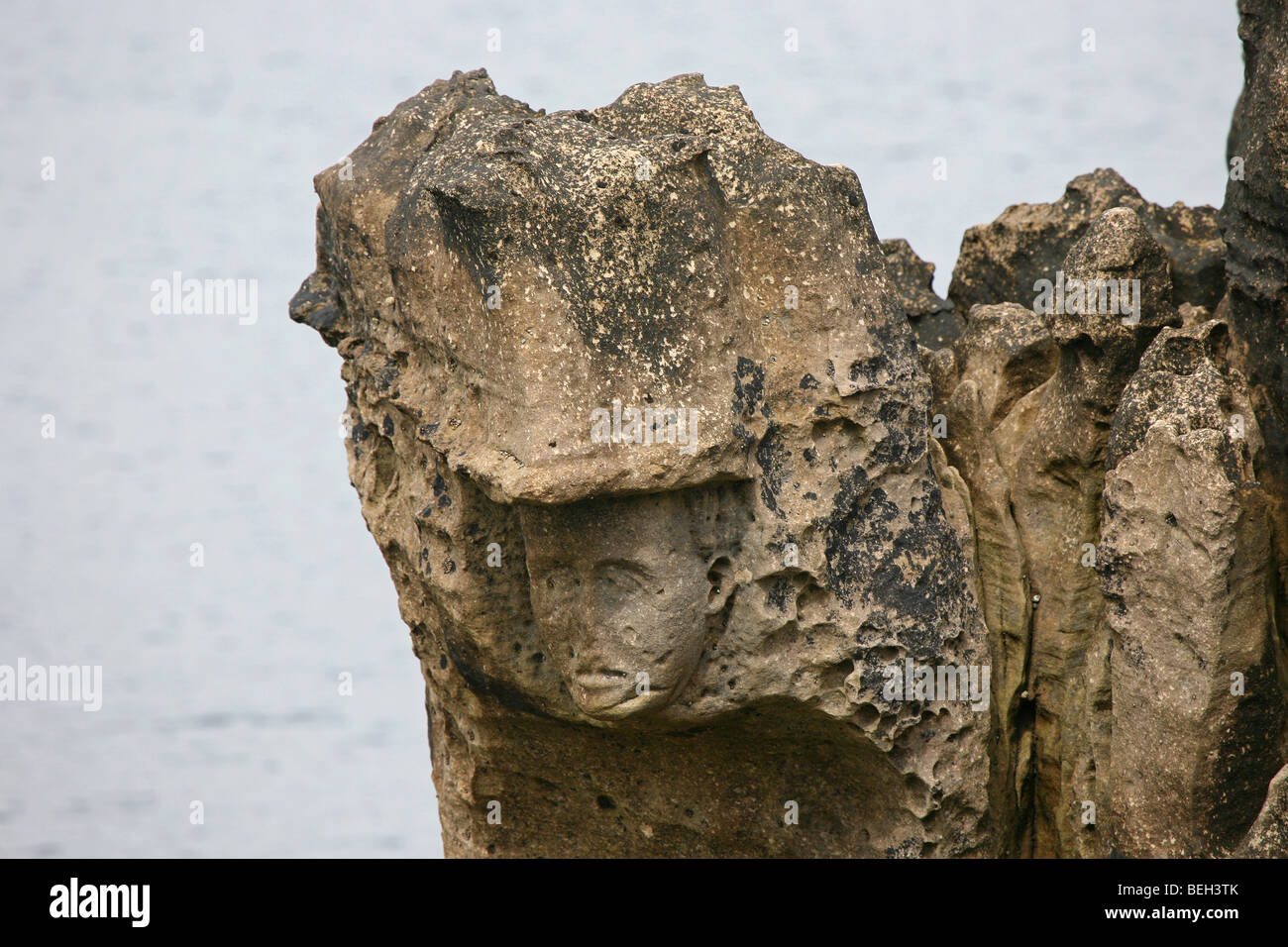 Un intaglio di 'i sacerdoti testa' vicino al bidone di diavoli a pentole rocce sulla costa di Antrim. L'Irlanda del Nord. Foto Stock