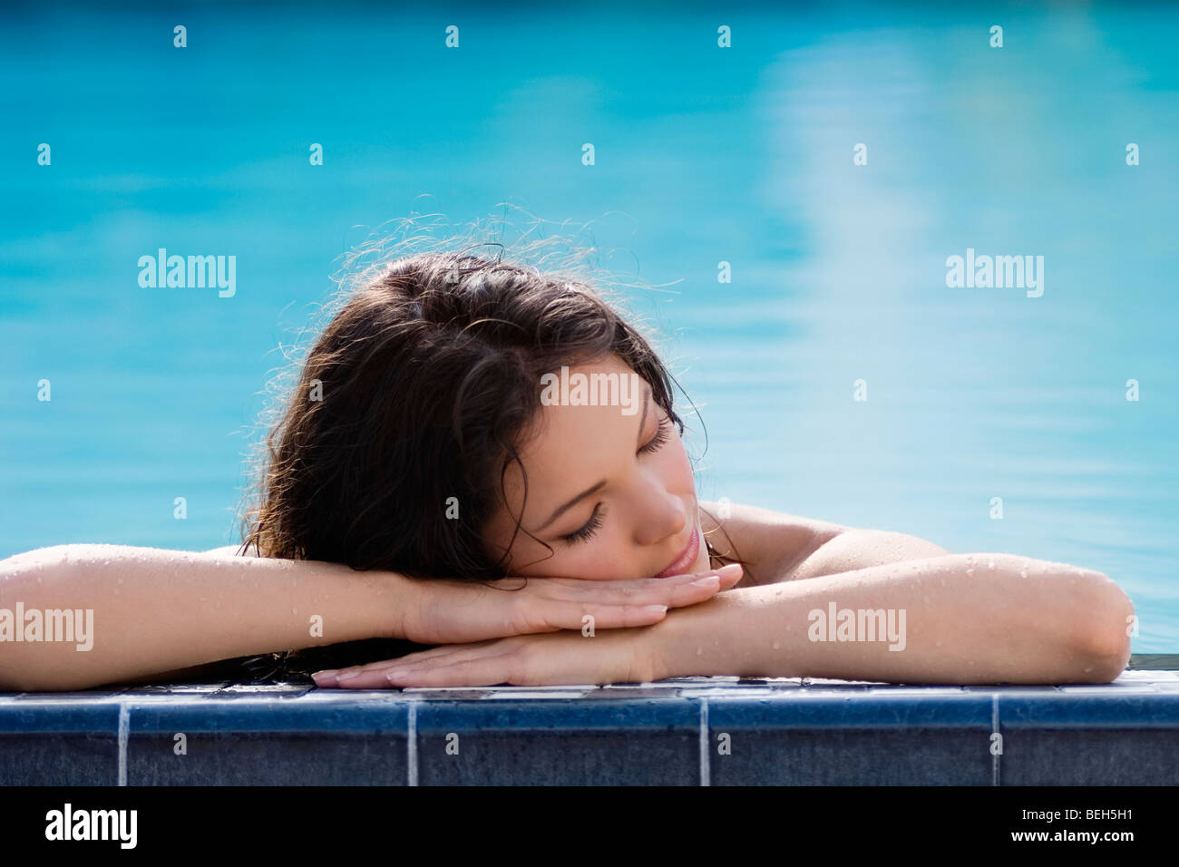 Giovane donna napping presso la piscina Foto Stock