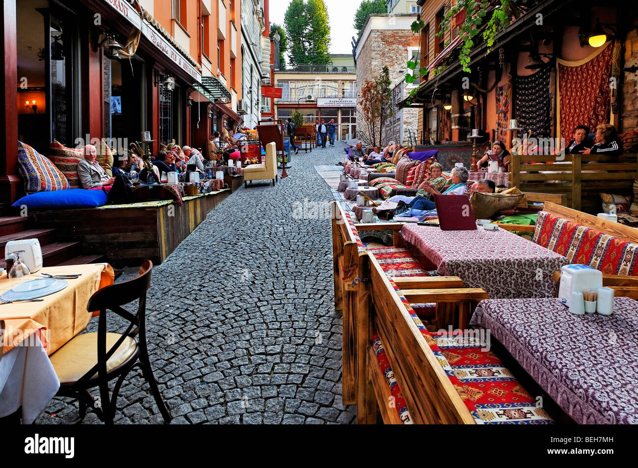I turisti rilassarsi in caffetterie in una tranquilla strada secondaria di Istanbul del distretto Sultahahmet Foto Stock