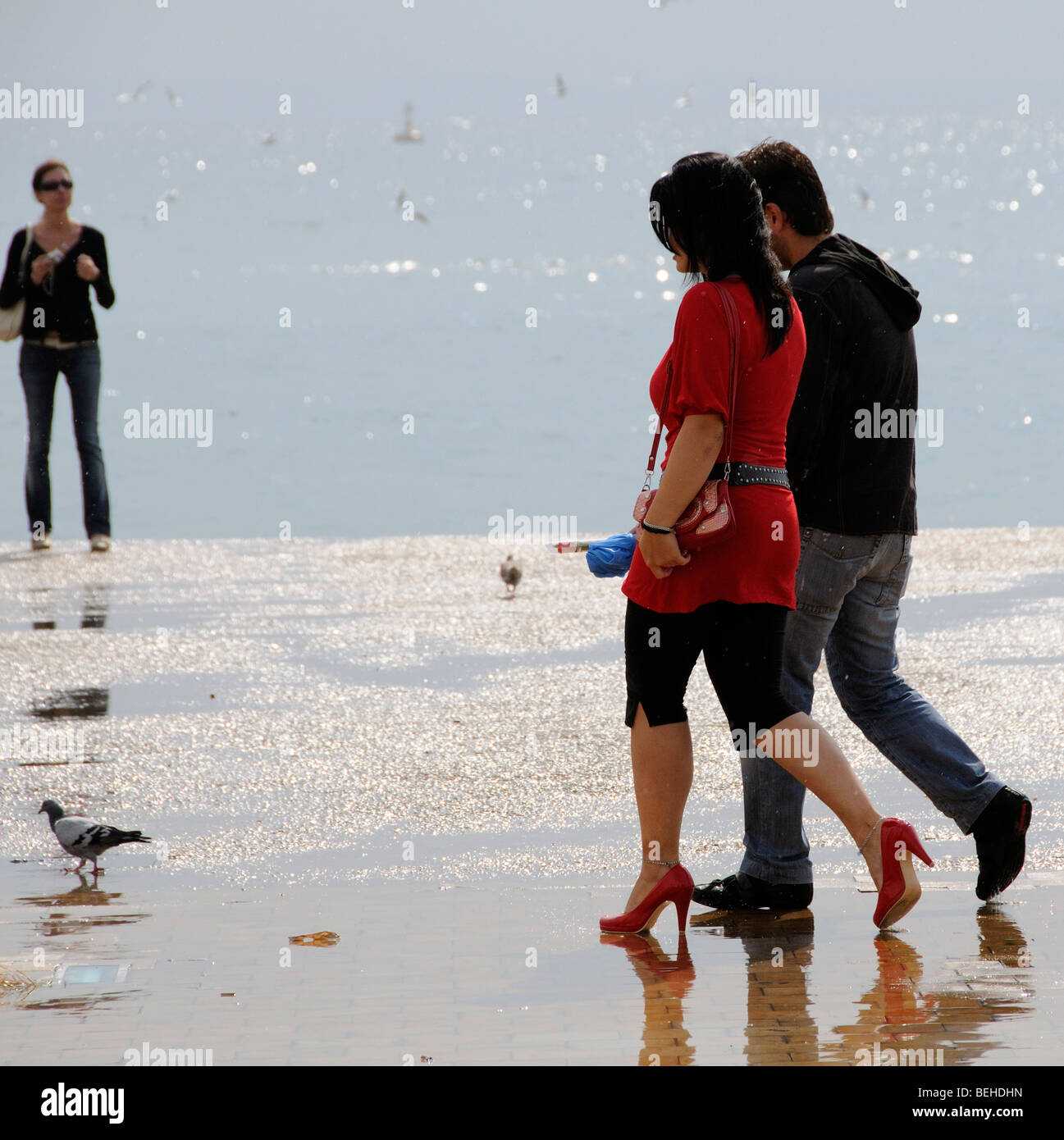 Giovane a piedi attraverso una pozza sul lungomare di Salonicco Grecia Foto Stock