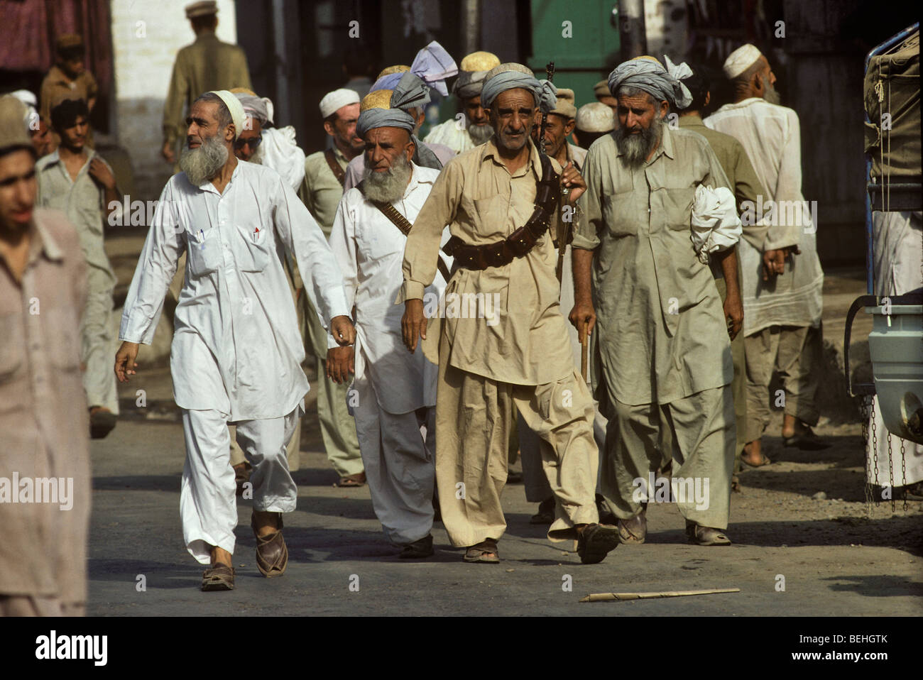 Pathan uomini a piedi la strada principale di Darra Adam Khel, frontiera di nord-ovest del Pakistan, Foto Stock