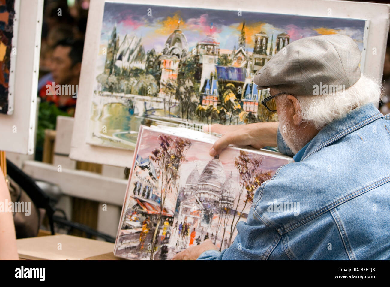 Un artista di strada aranging il suo lavoro per la visualizzazione in Place Du Tertre a Montmartre Parigi Francia Foto Stock
