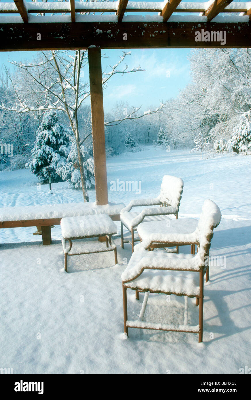 Nuova neve sul ponte e mobili da giardino incandescente in inverno la luce del mattino besdie la casa, midwest USA Foto Stock