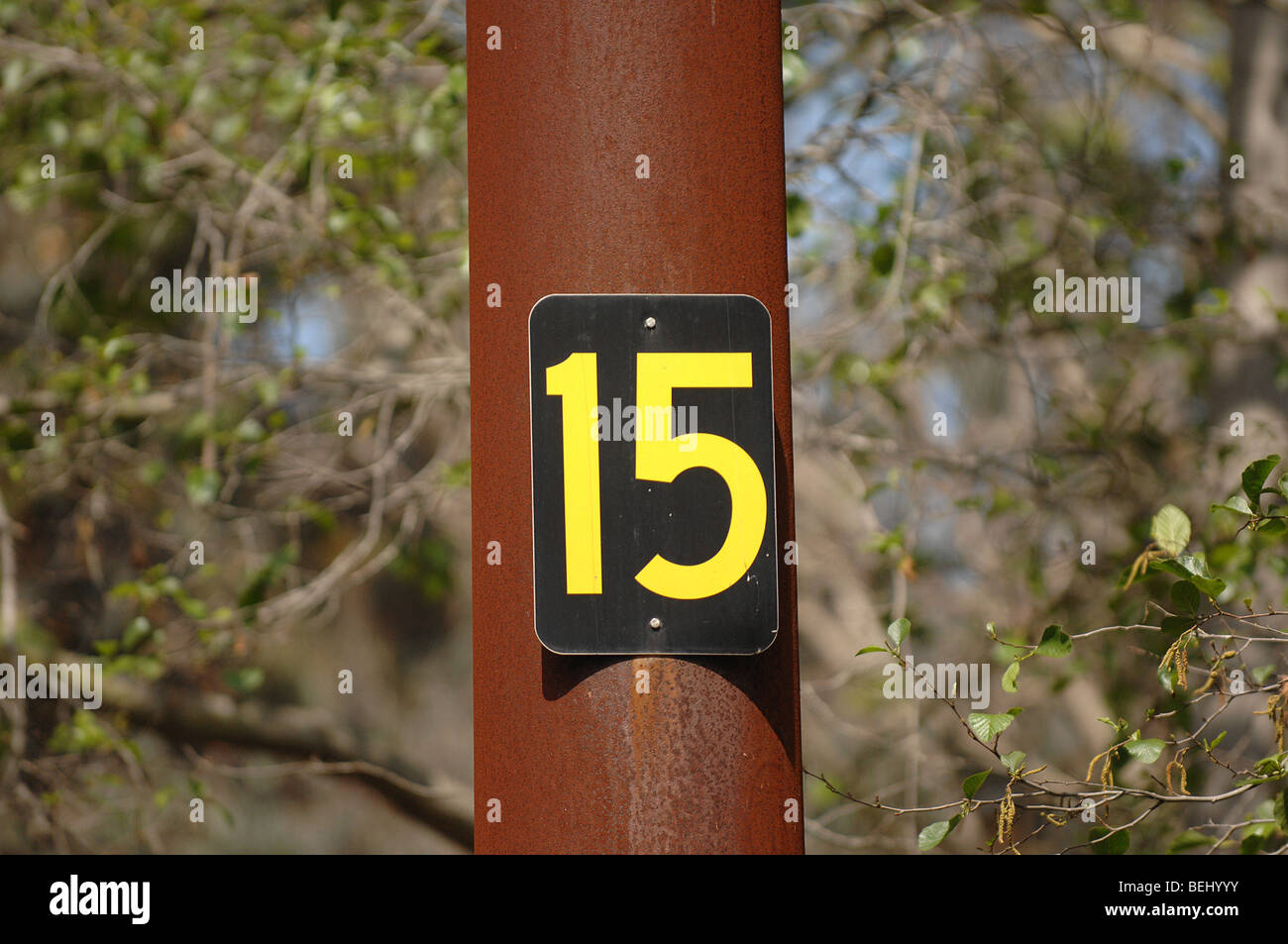 Un segno con il numero 15 pubblicato su un palo arrugginito. Foto Stock