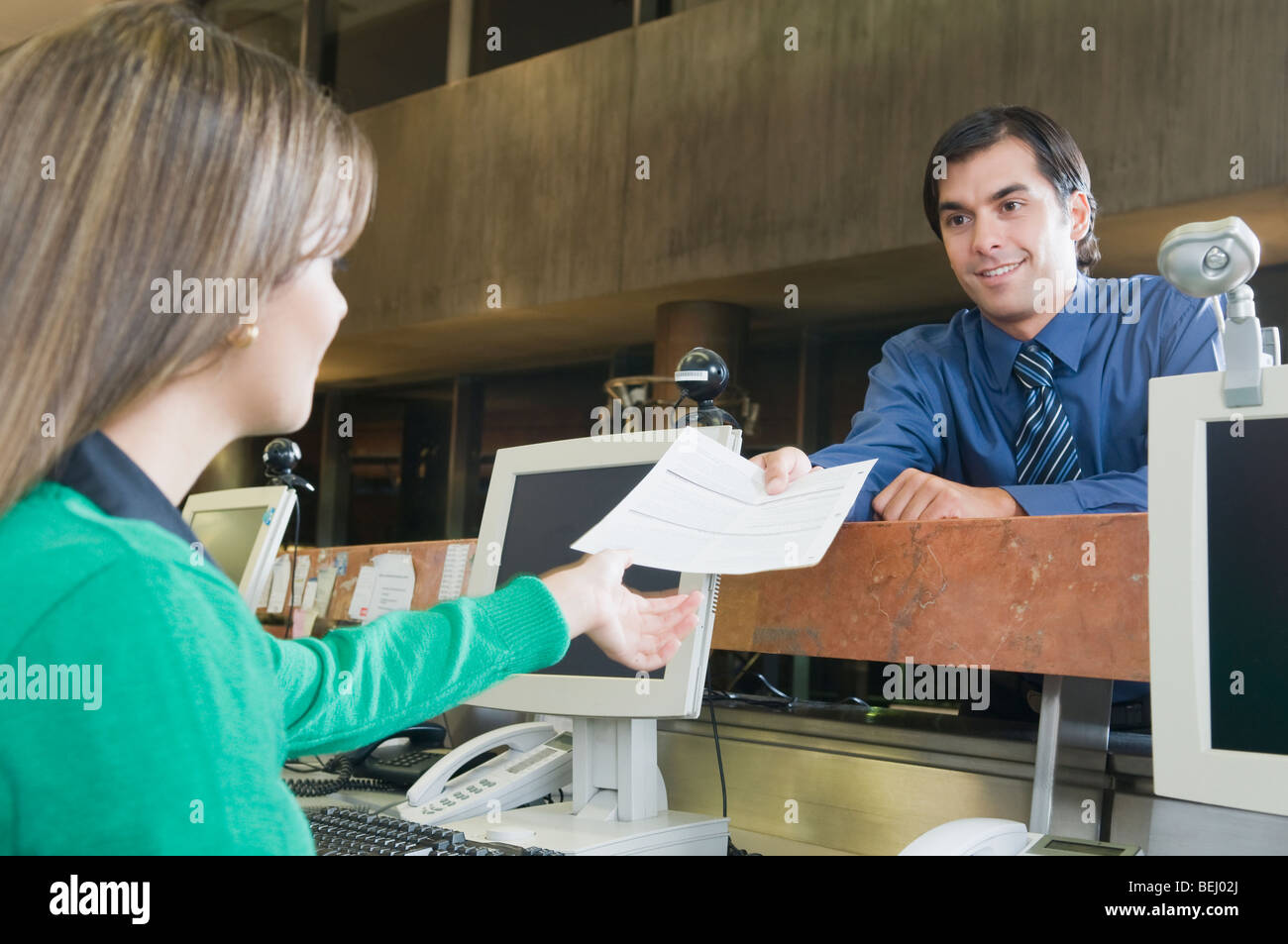 Uomo di dare un documento a femmina rappresentante del servizio clienti Foto Stock