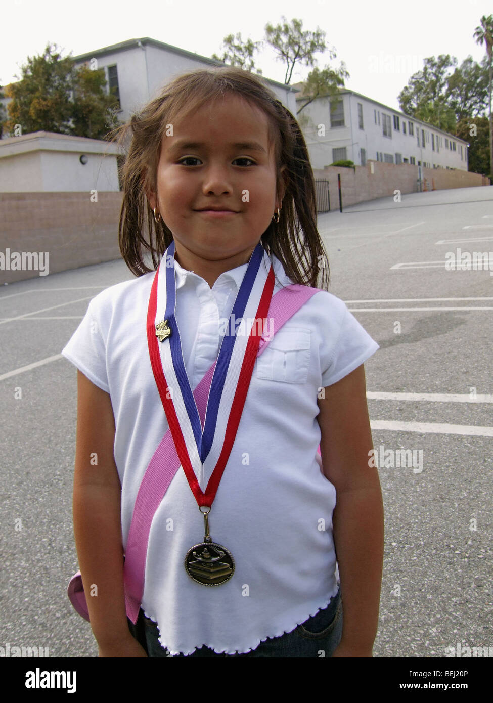Ragazza che indossa la medaglia sulla scuola Foto Stock