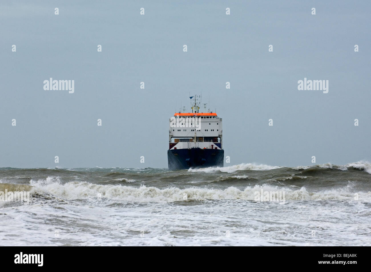 Contenitore nave in un mare agitato con grandi onde durante la tempesta di neve Foto Stock