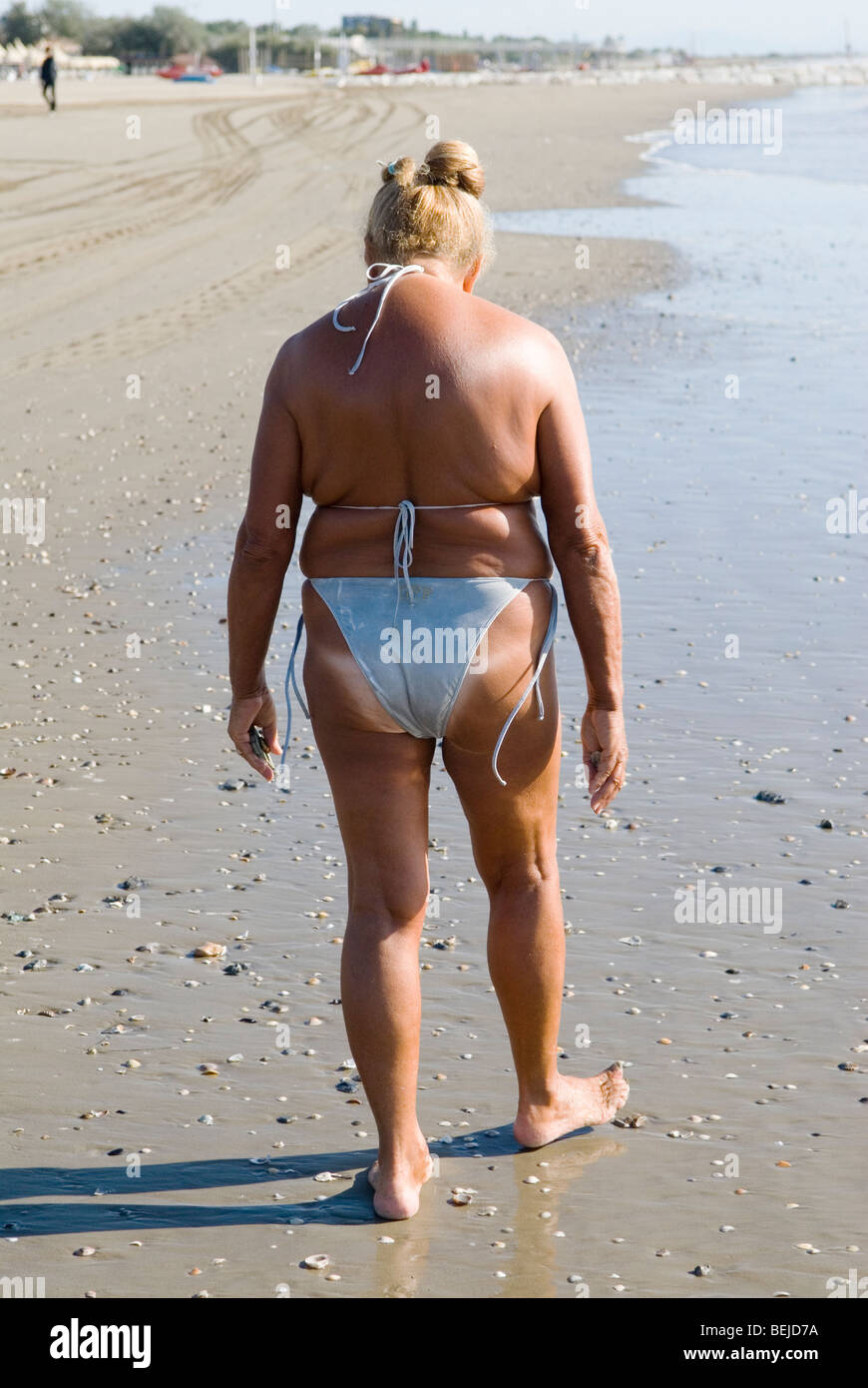 Genderfluid persona anziana matura donna uomo sano corpo in forma indossando bikini bianco Lido di Venezia spiaggia Italia 2000S.. 2009 HOMER SYKES Foto Stock
