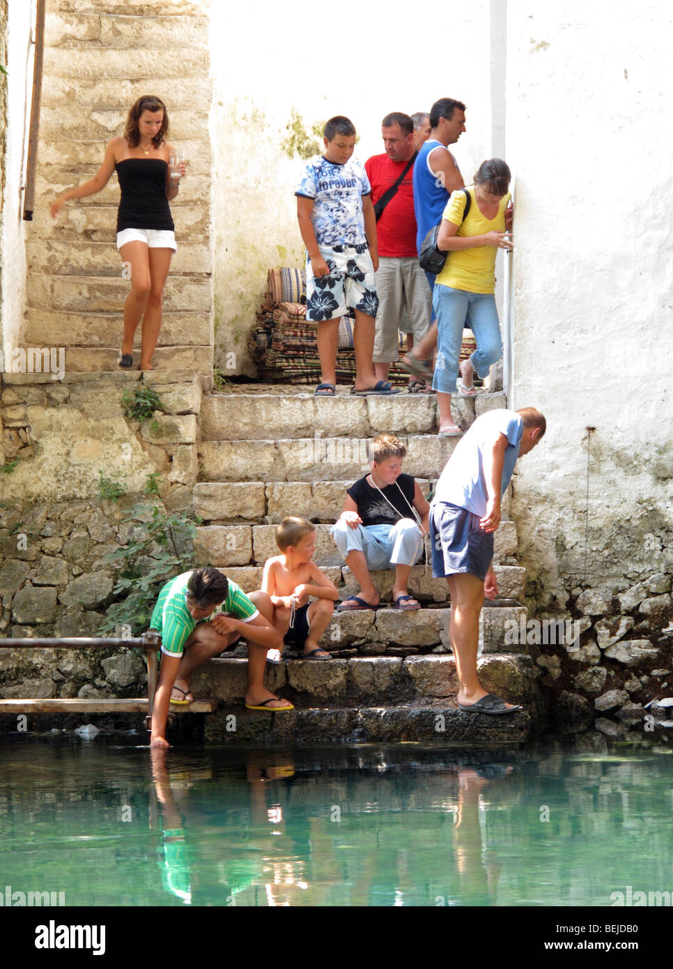 Le persone sulla scalinata per raggiungere l'acqua dal fiume. A Dervis Tekija in Blagaj sul fiume Buna fonte. Foto Stock