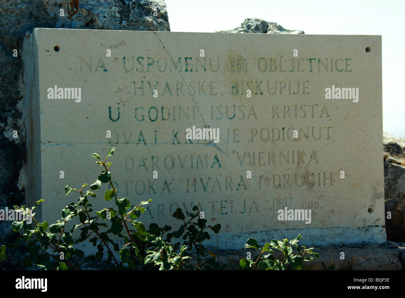 Una lapide commemorativa dal grande crocifisso su Sv. Nikola picco, Isola di Hvar, Croazia Foto Stock