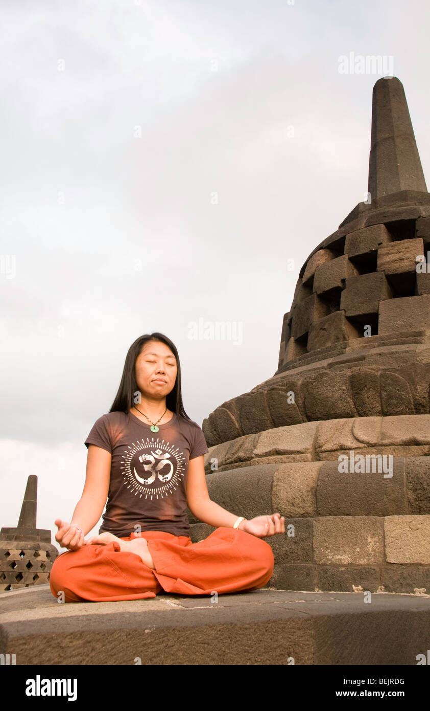 La donna a praticare lo yoga al tempio di Borobudur, Java, Indonesia Foto Stock