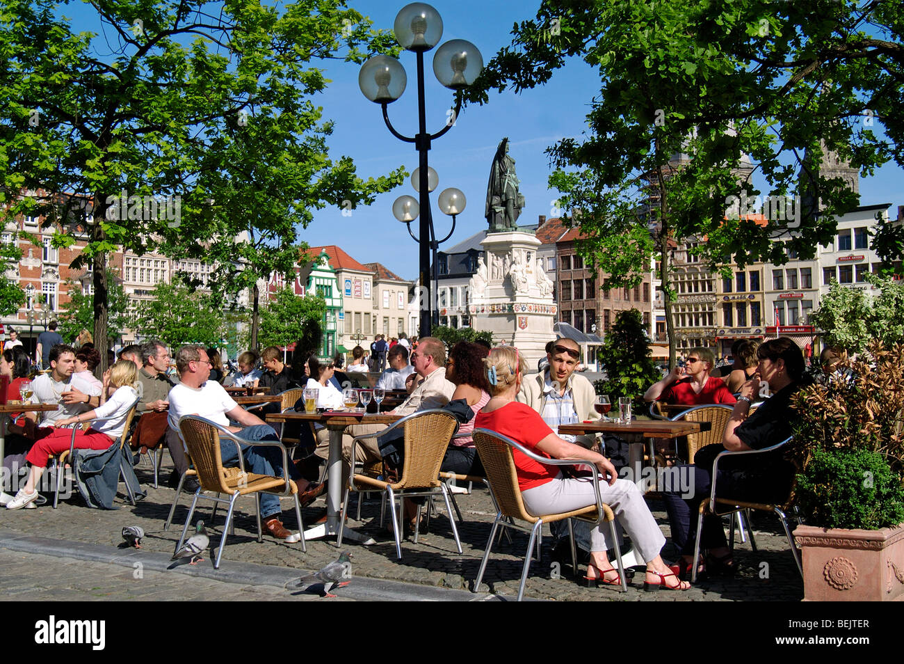 I turisti a sedersi in un marciapiede sul mercato del venerdì a Gand, Belgio Foto Stock