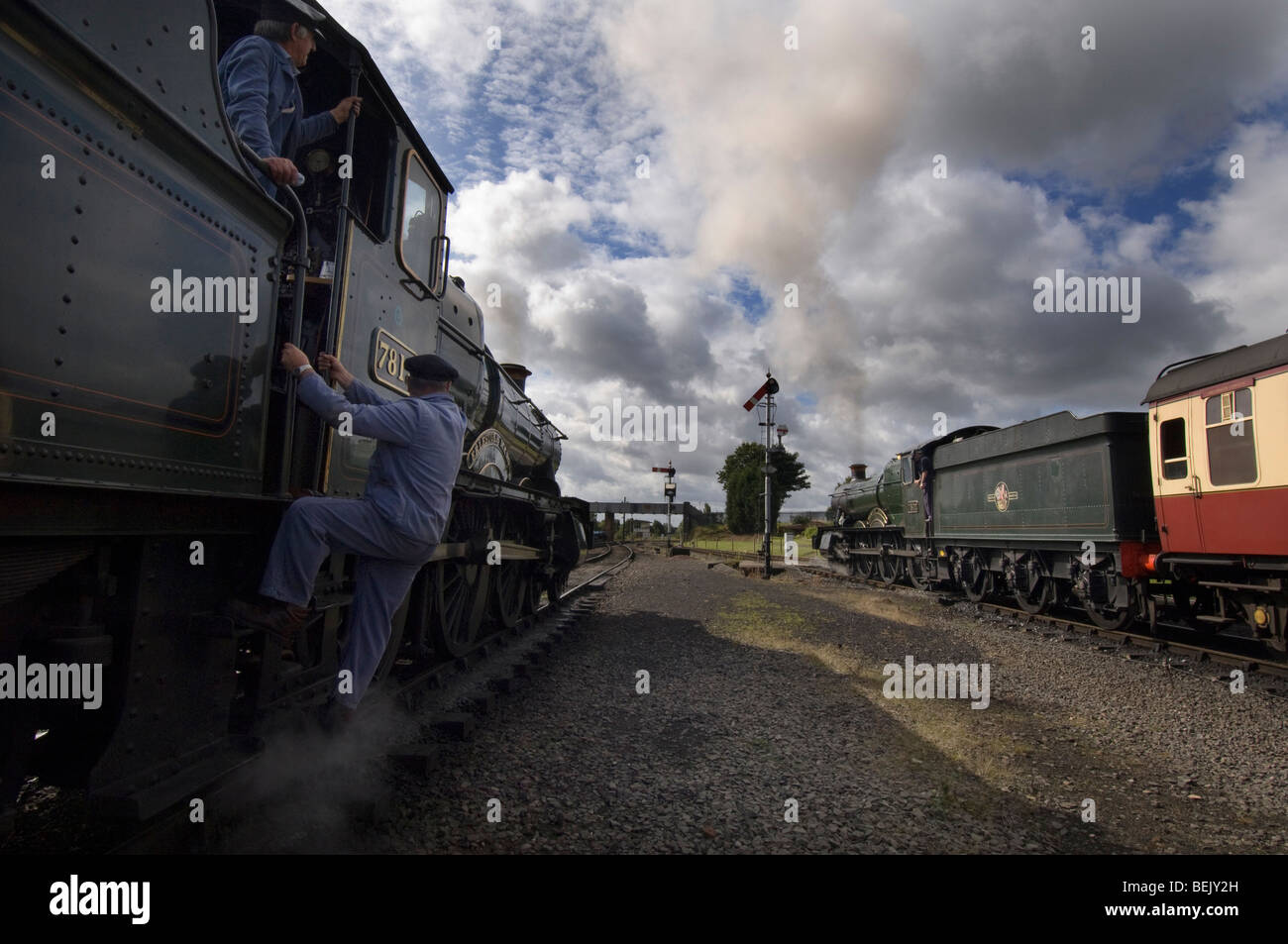 Un driver di motore arrampicata in cabina di un treno a vapore su conserve di Severn Valley Railway a Kidderminster, Shropshire Foto Stock