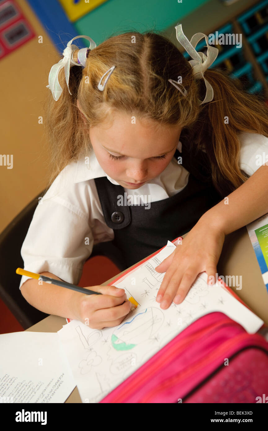 Una fase chiave due giovane ragazza che lavora in una classe di una piccola lingua gallese medie scuola primaria, Aberystwyth Wales UK Foto Stock