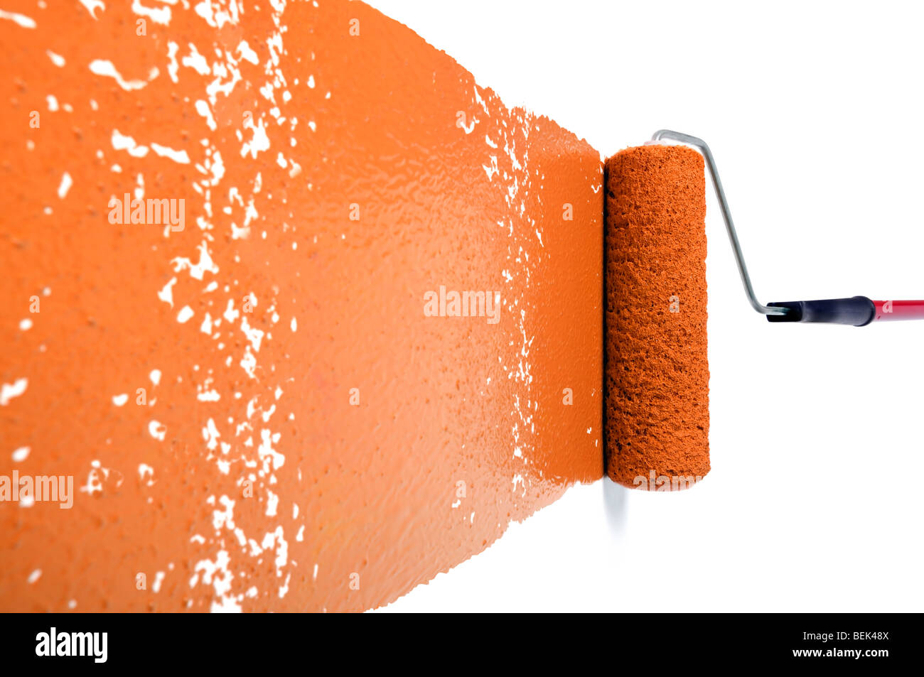 Rullo di dolore con vernice arancione sul muro bianco Foto Stock