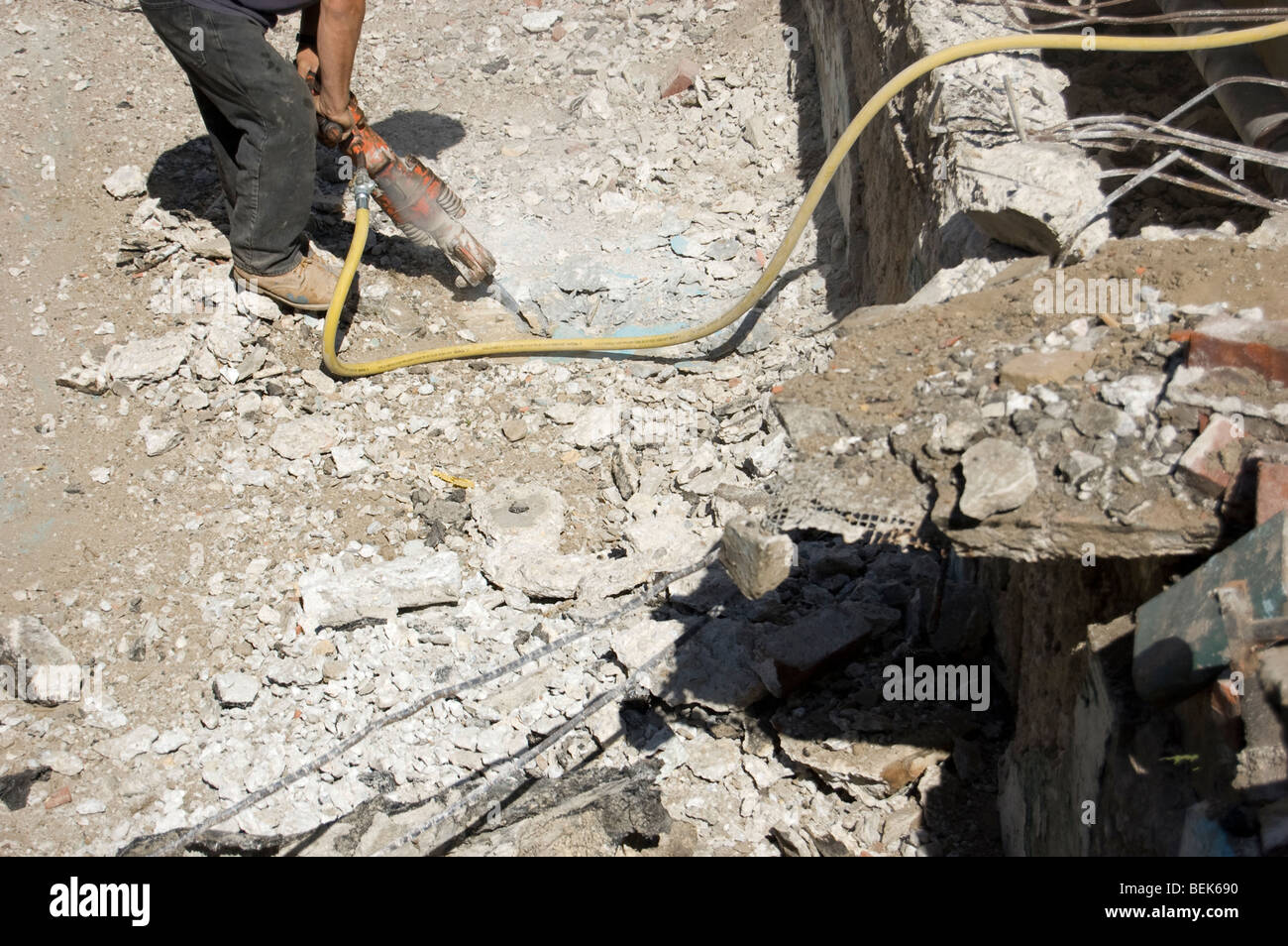 Operaio edile scava in un cantiere utilizzando un jackhammer Foto Stock