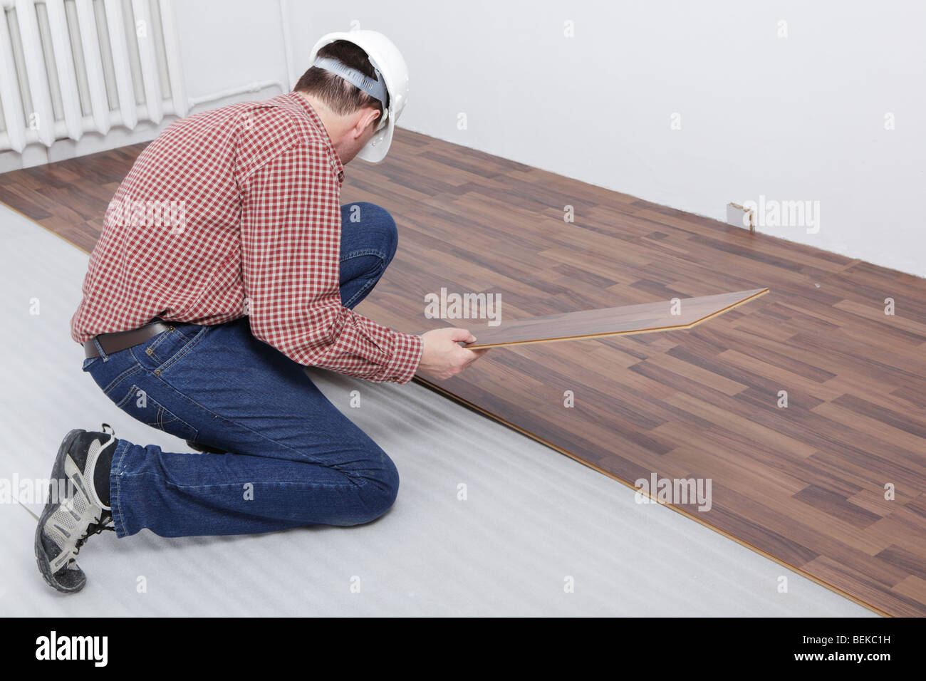 L'uomo rendendo il pavimento laminato l'installazione Foto Stock