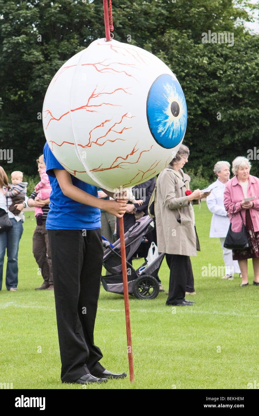 Ragazzo tenendo un gigantesco globo oculare durante il St Albans Albantide pellegrinaggio Foto Stock