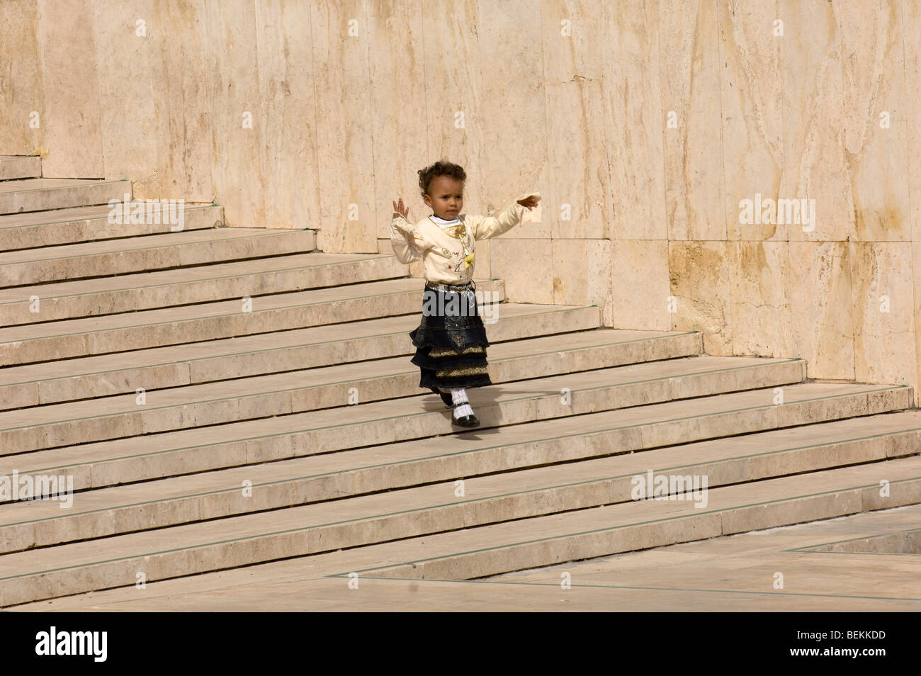 Una piccola ragazza marocchina corre giù per una scalinata nel Cortile della moschea di Hassan II, Casablanca, Marocco, Africa Foto Stock