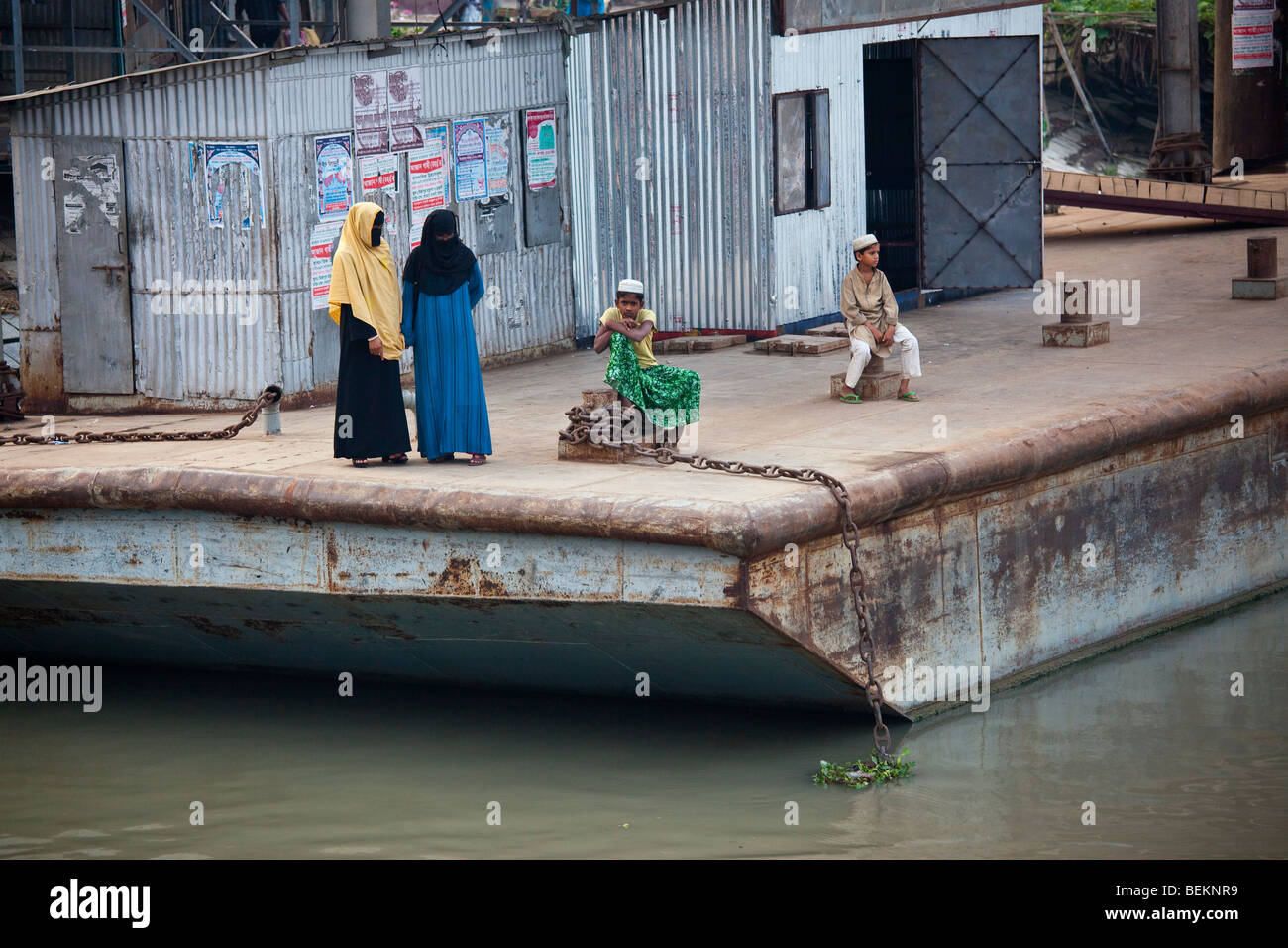 I musulmani in attesa sul dock per il razzo in barca a remi sul fiume Brahmaputra in Bangladesh Foto Stock