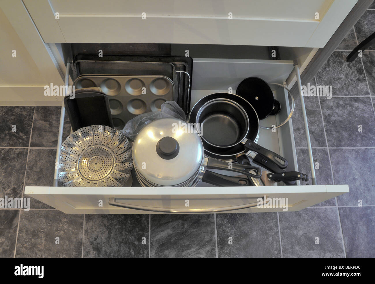 Guardando verso il basso su una cucina aperta cassetto impilato con pentole e padelle. Foto Stock