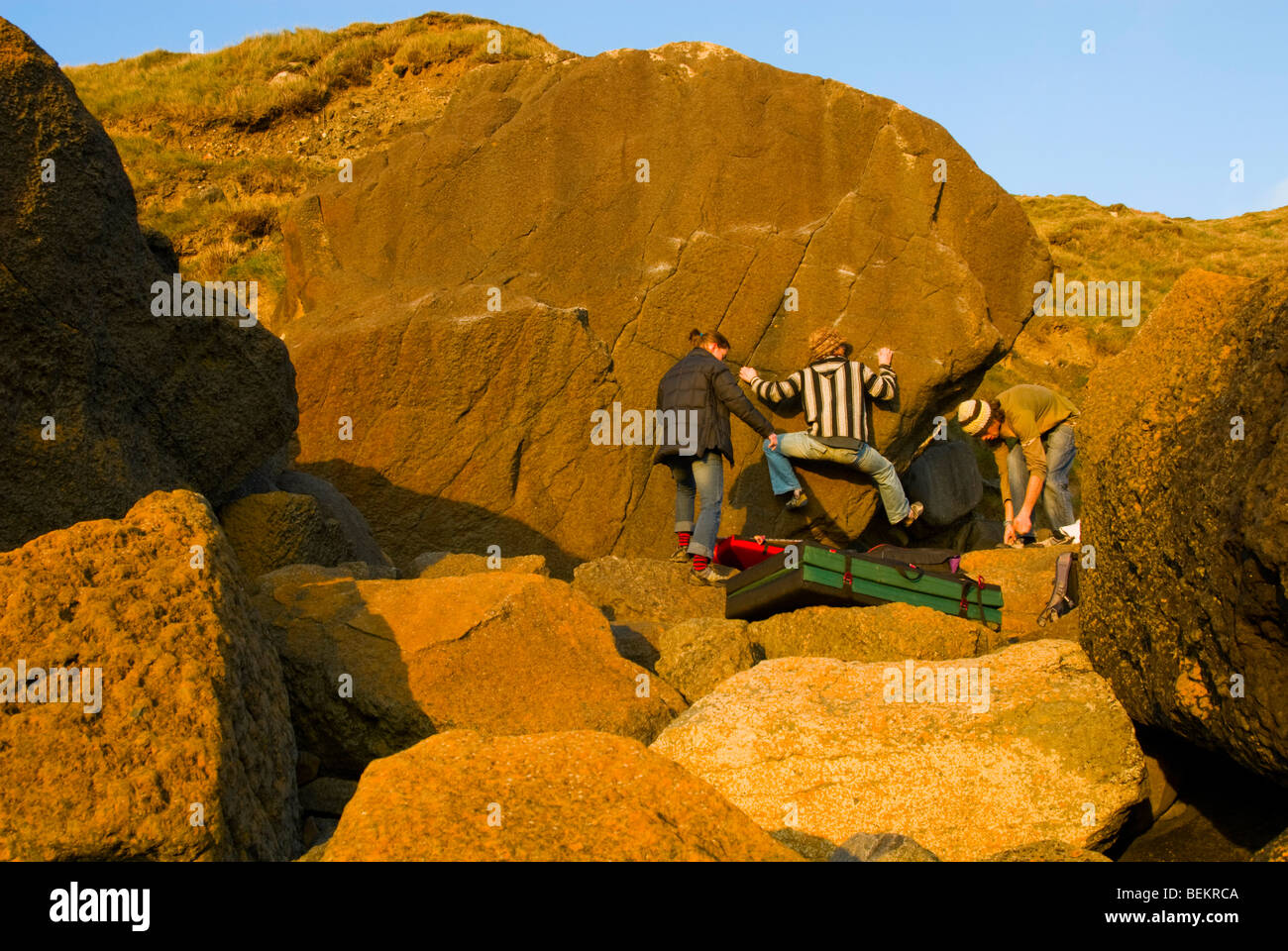 Gli alpinisti bouldering in inverno nel sole pomeridiano a Porth Ysgo Galles Foto Stock
