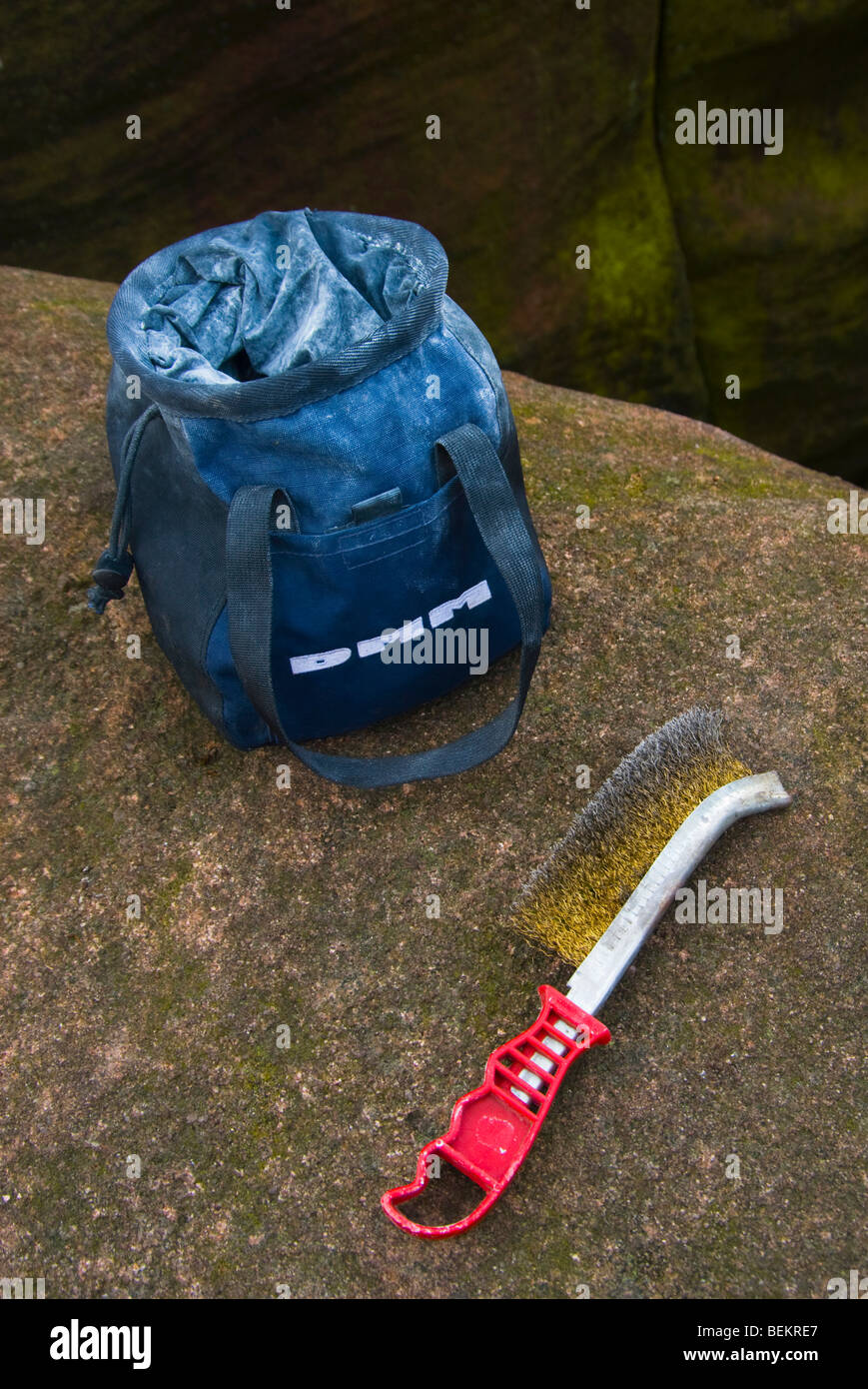 Gli alpinisti chalk bag e filo di tenere la spazzola di pulizia su un masso di gritstone Foto Stock