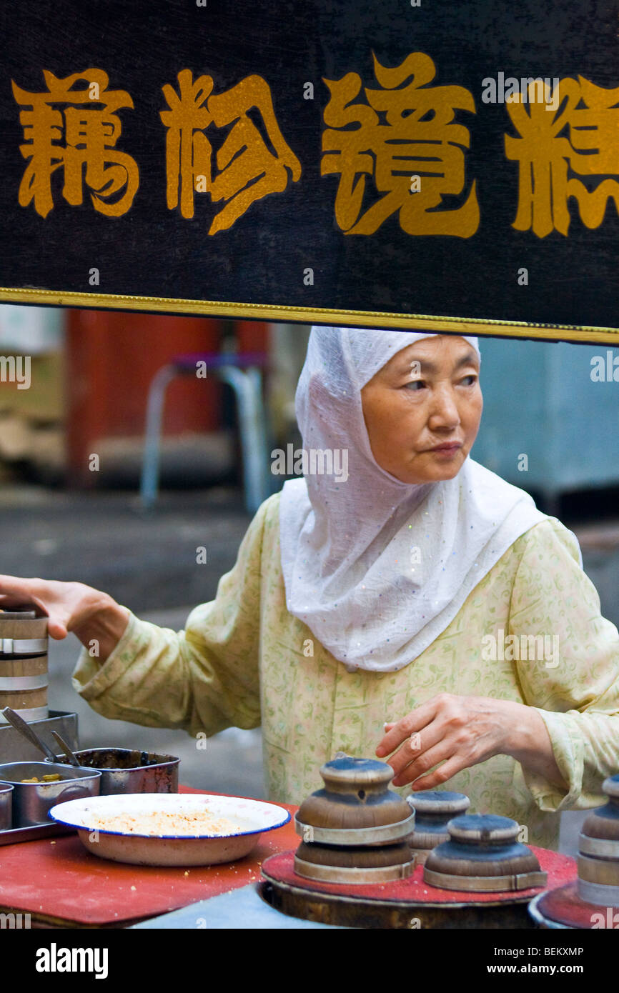 Donna musulmana street food fornitore nel Quartiere Musulmano di Xian Cina Foto Stock