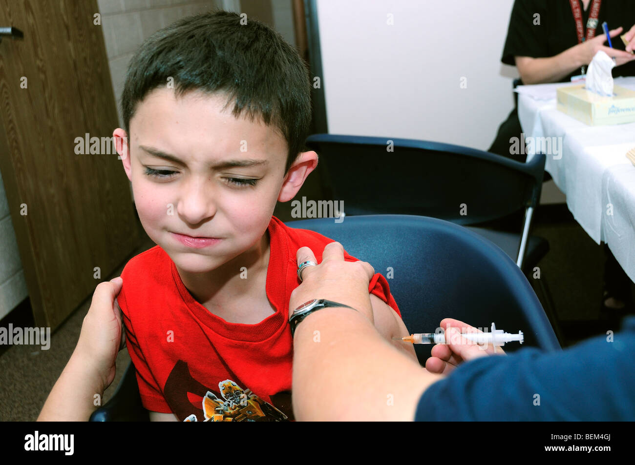 Un 8-anno-vecchio ragazzo viene vaccinato per il 2009 H1N1 dell'influenza, noto anche come l'influenza suina, con un'influenza inattivato shot. Foto Stock