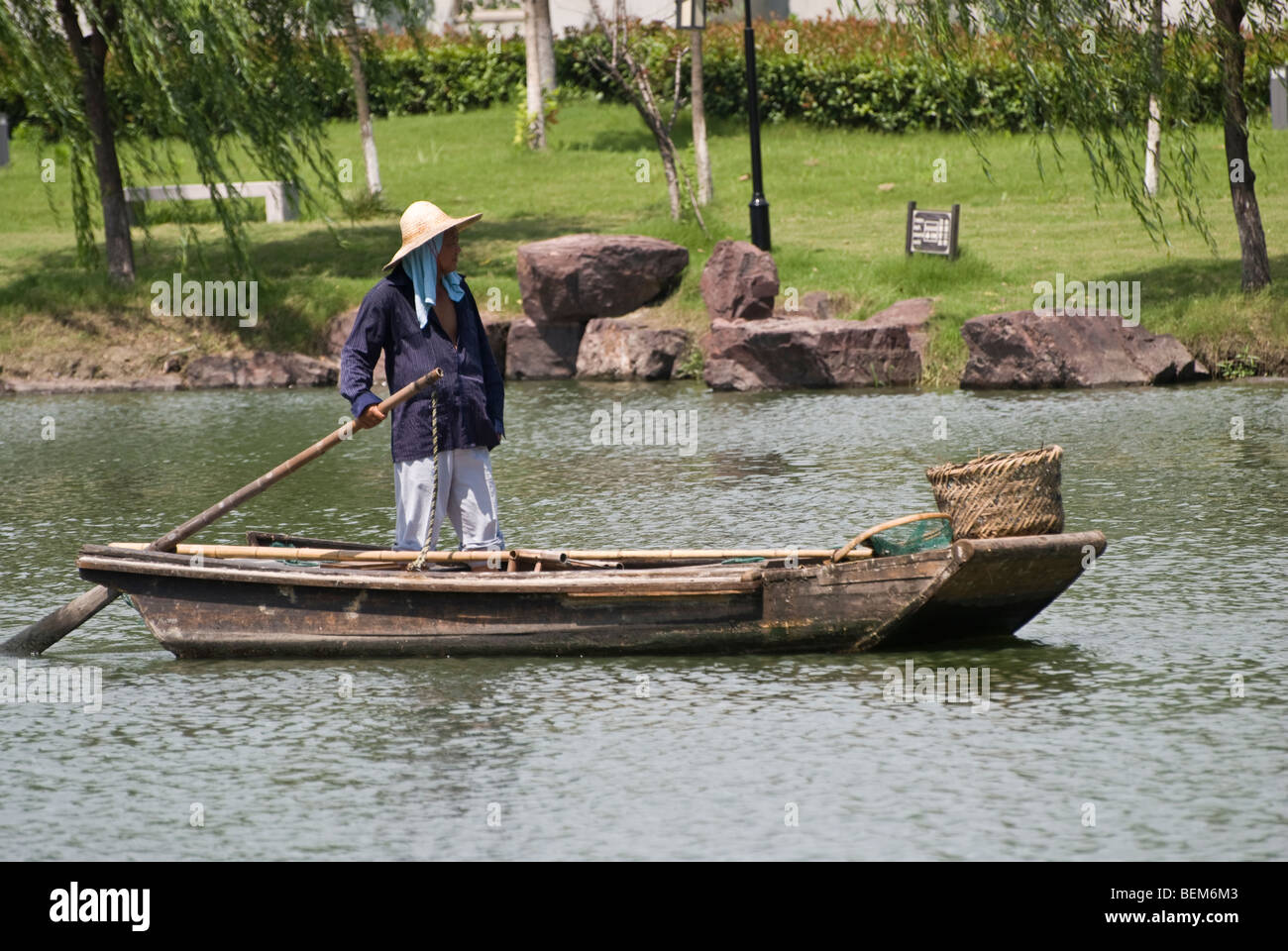 Uomo in un antica barca di legno in un fiume di Xitang Xitang è un antica città scenica in Jiashan County, nella provincia di Zhejiang, in Cina. Foto Stock