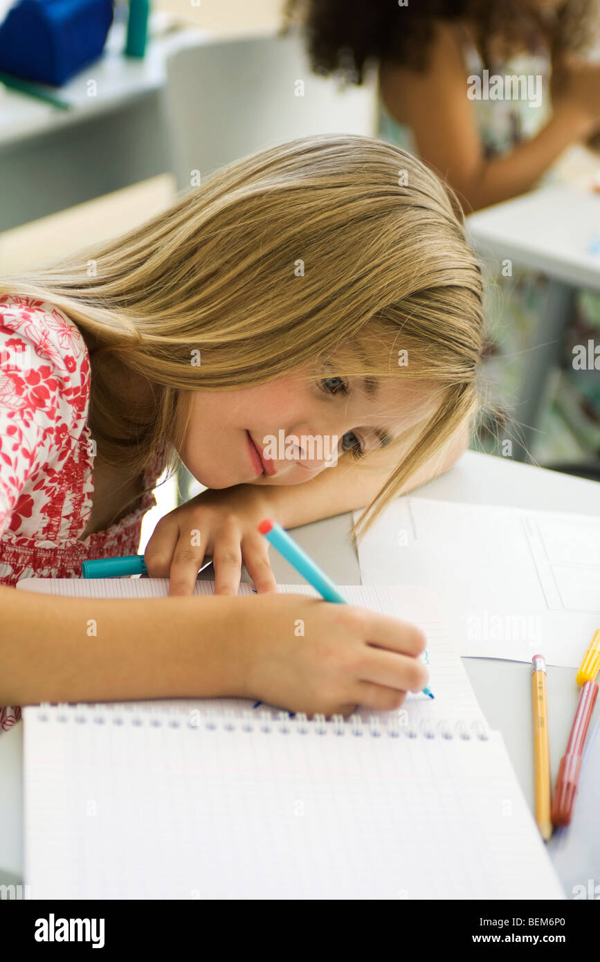 Ragazza testa in appoggio sul braccio, disegno in notebook Foto Stock