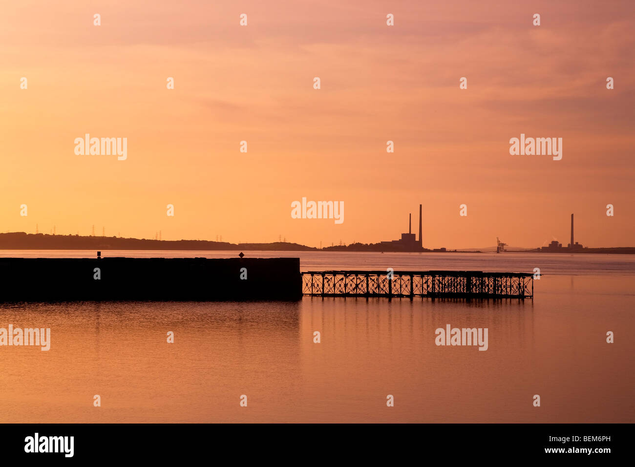 Il vecchio molo con Tarbert Power Station oltre il fiume Shannon, County Kerry, Irlanda Foto Stock