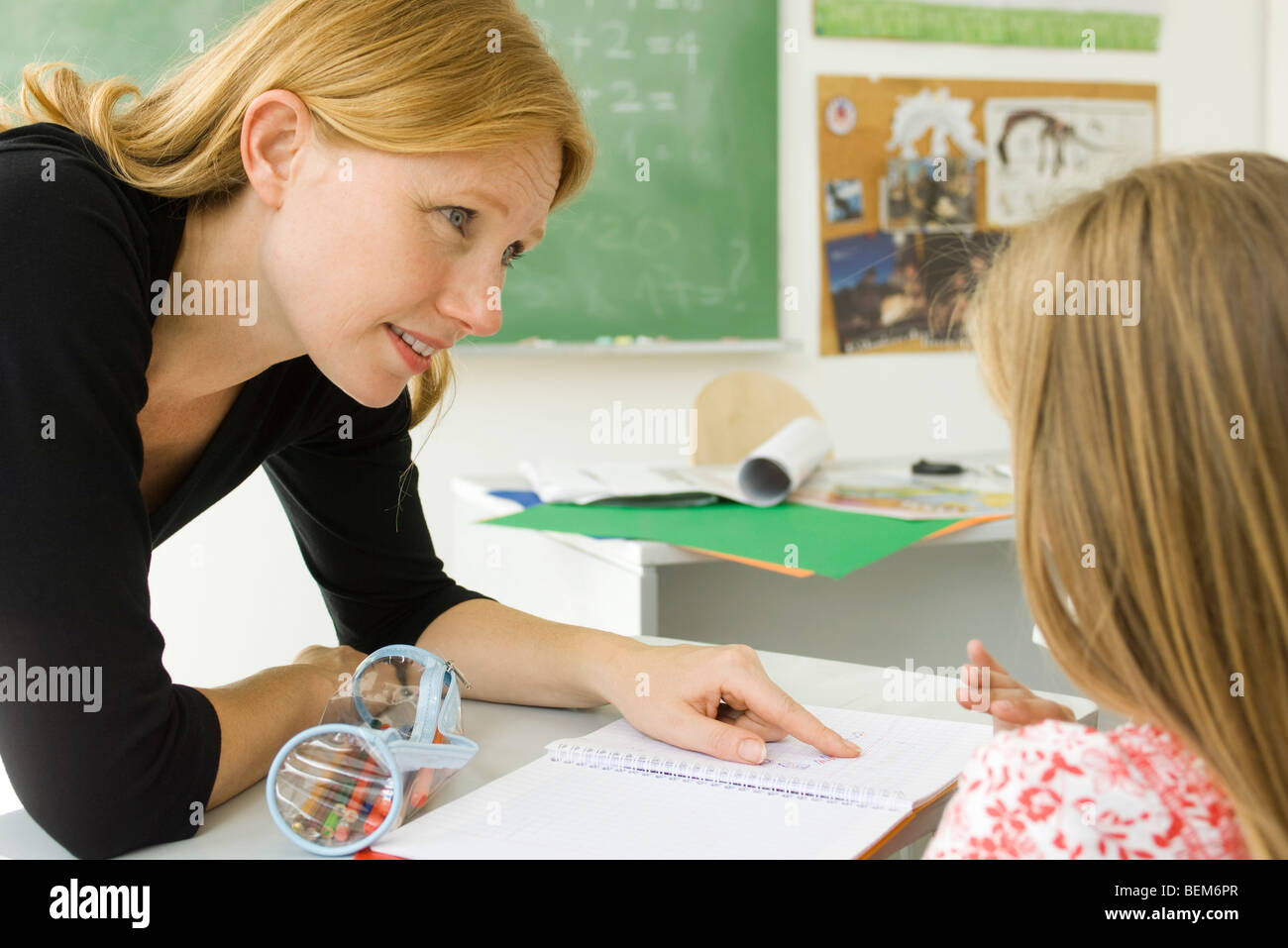 Insegnante elementare aiutare lo studente con il lavoro Foto Stock