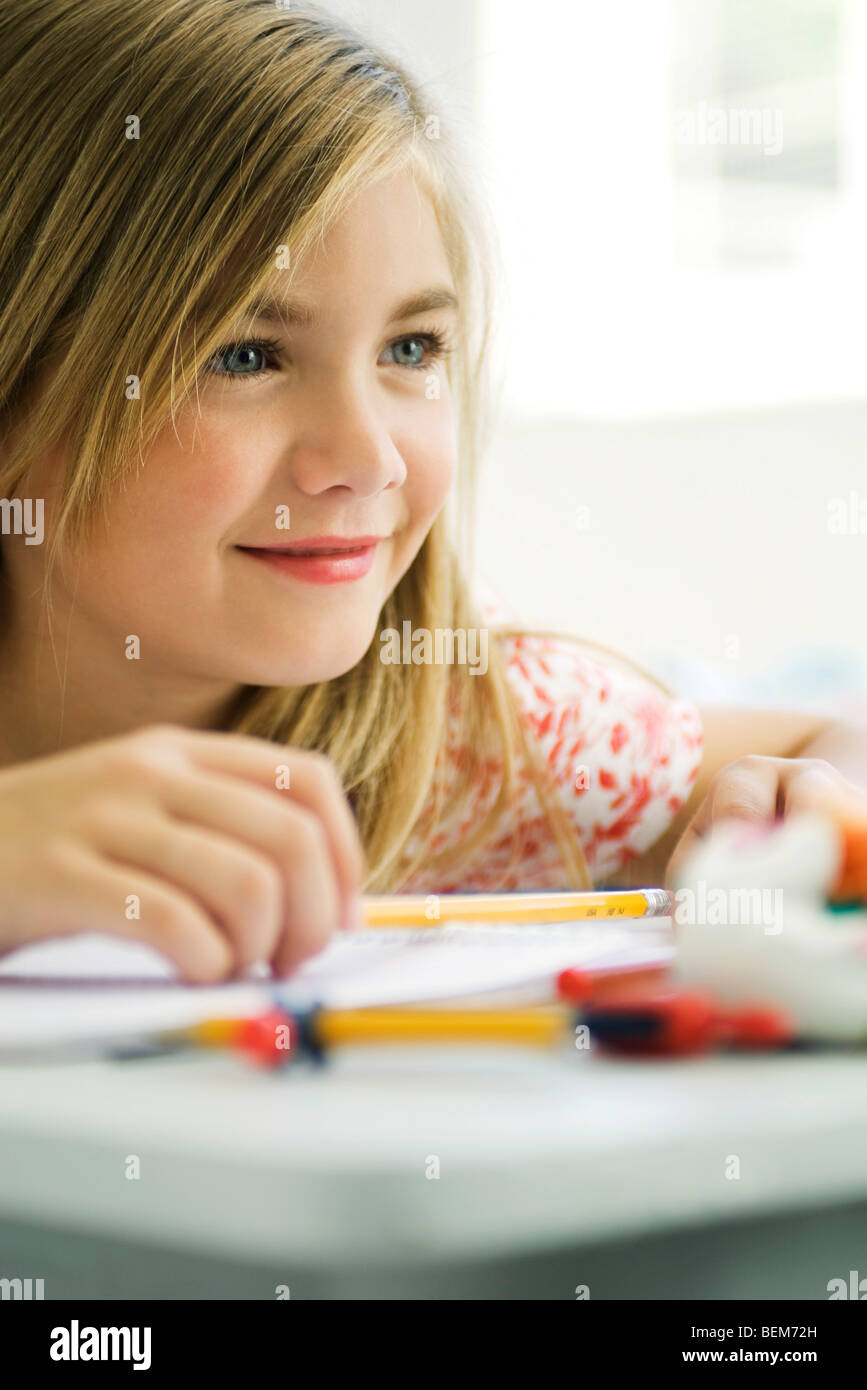 Ragazza fantasticando al banco di scuola Foto Stock