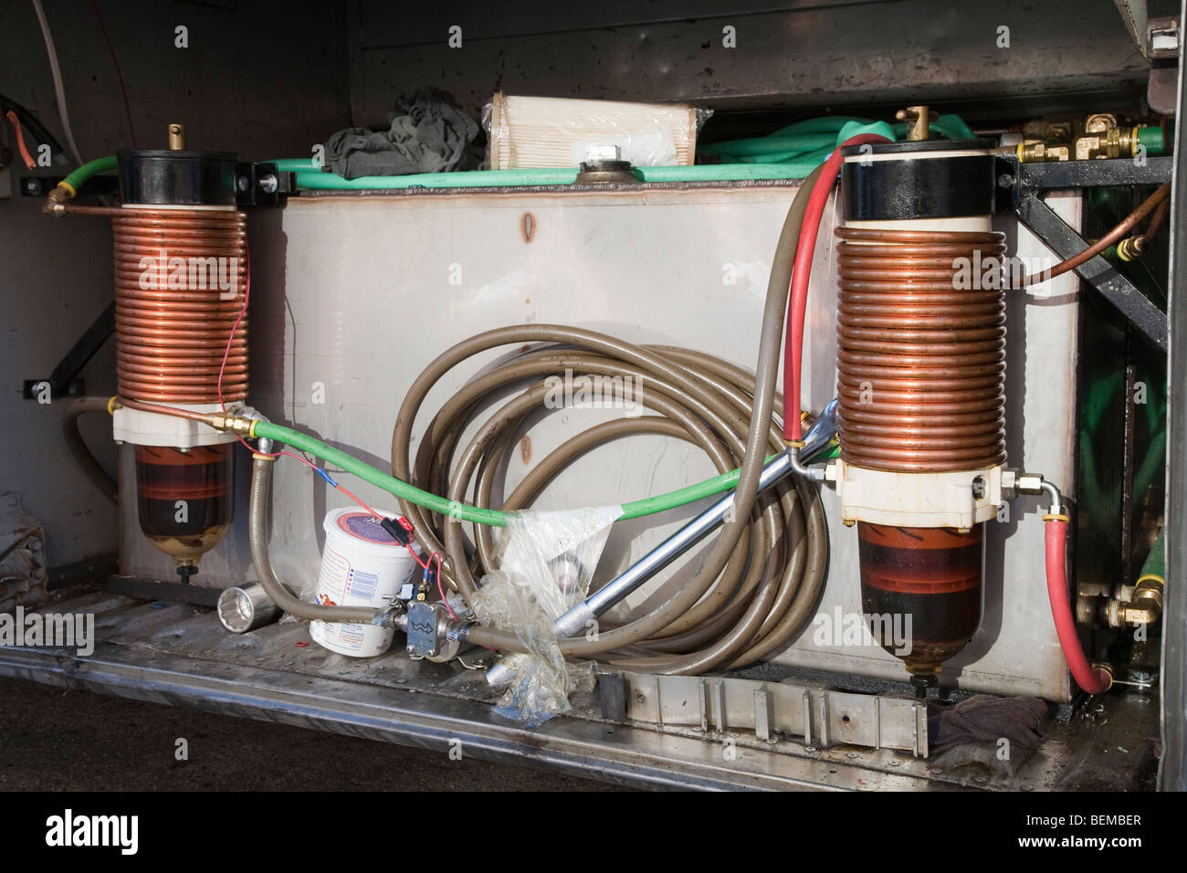 Una chiusura di un olio vegetale di storage e sistema di filtrazione in un bagagliaio di una visione comune bus. Foto Stock