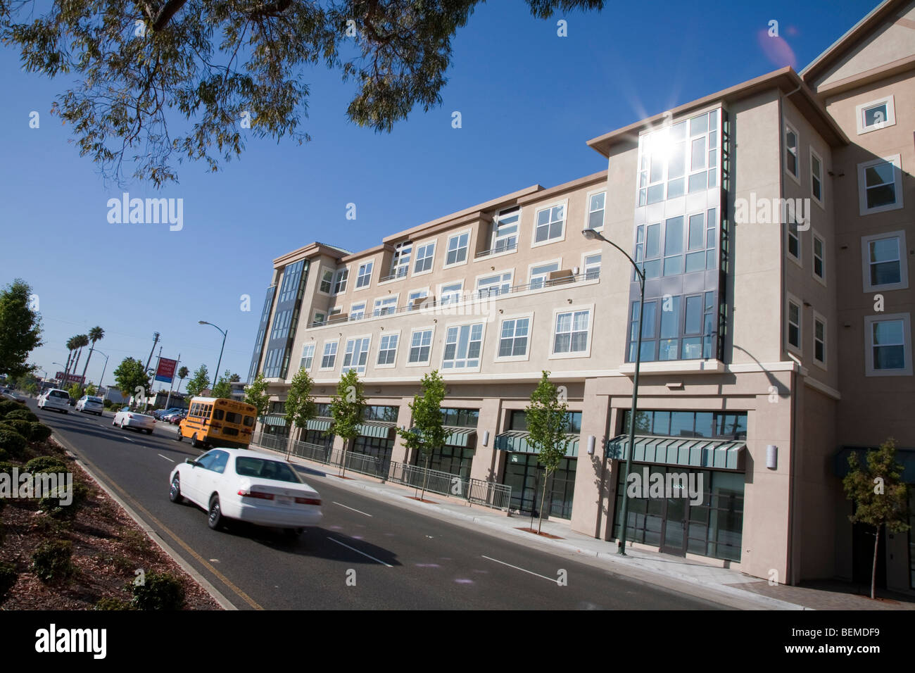 Un inclinato in vista di un edificio con appartamenti e uffici, visto da una divisa road. Park Broadway, El Camino Real, Millbrae Foto Stock