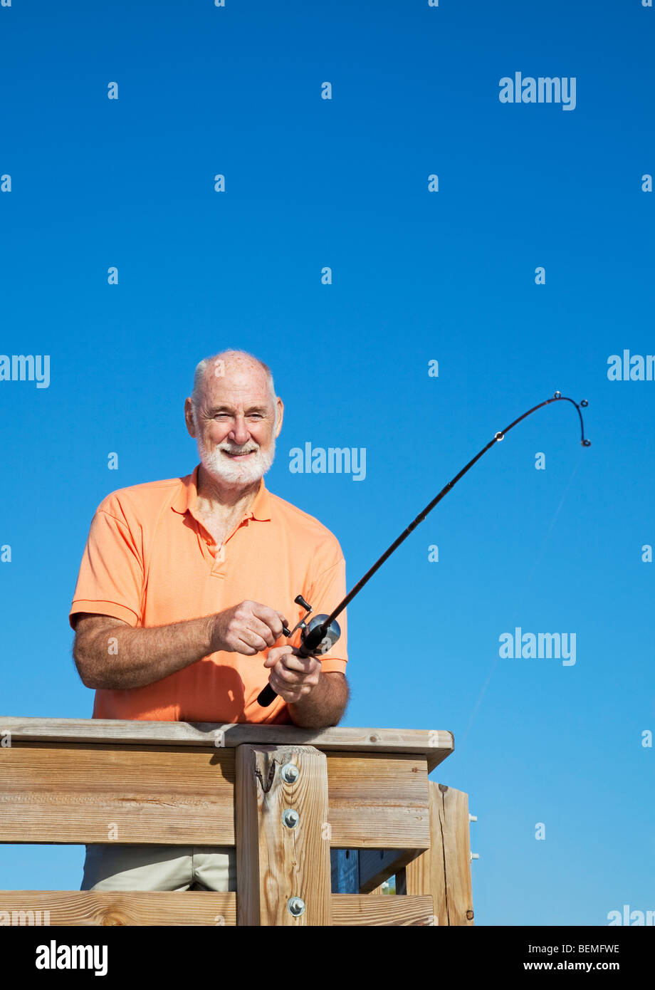 Senior pensionati uomo fising off di un molo. Vista verticale con una stanza per il testo. Foto Stock