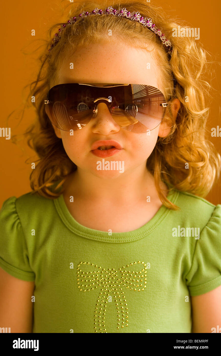 A quattro anni di bambina gioca dress up nella sua mamma del occhiali da sole. Foto Stock