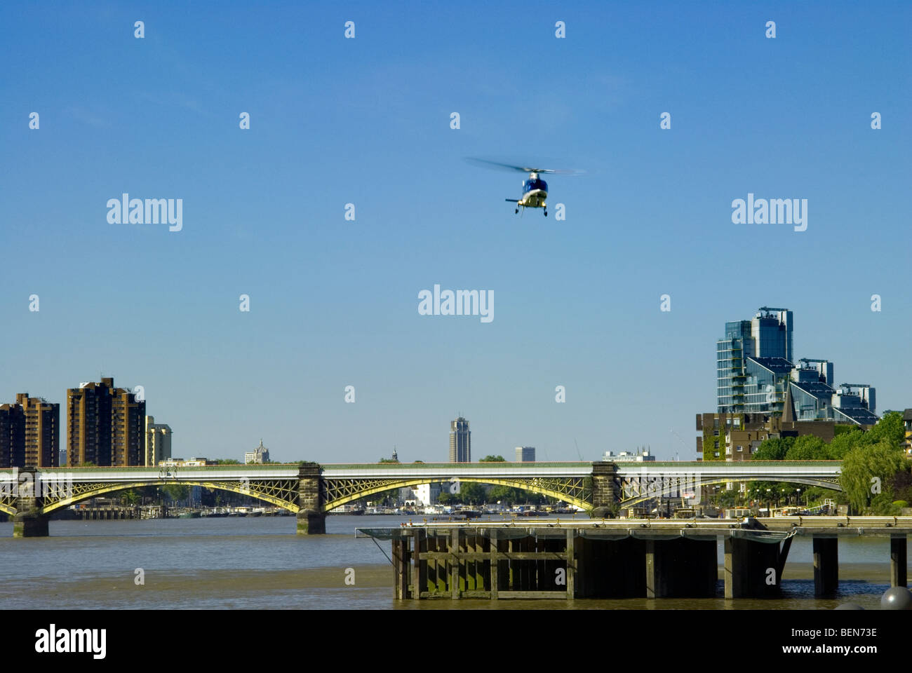 L Eliporto di Londra o di Battersea eliporto con elicottero venuta in terra in una bella giornata con Battersea ponte ferroviario dietro Foto Stock