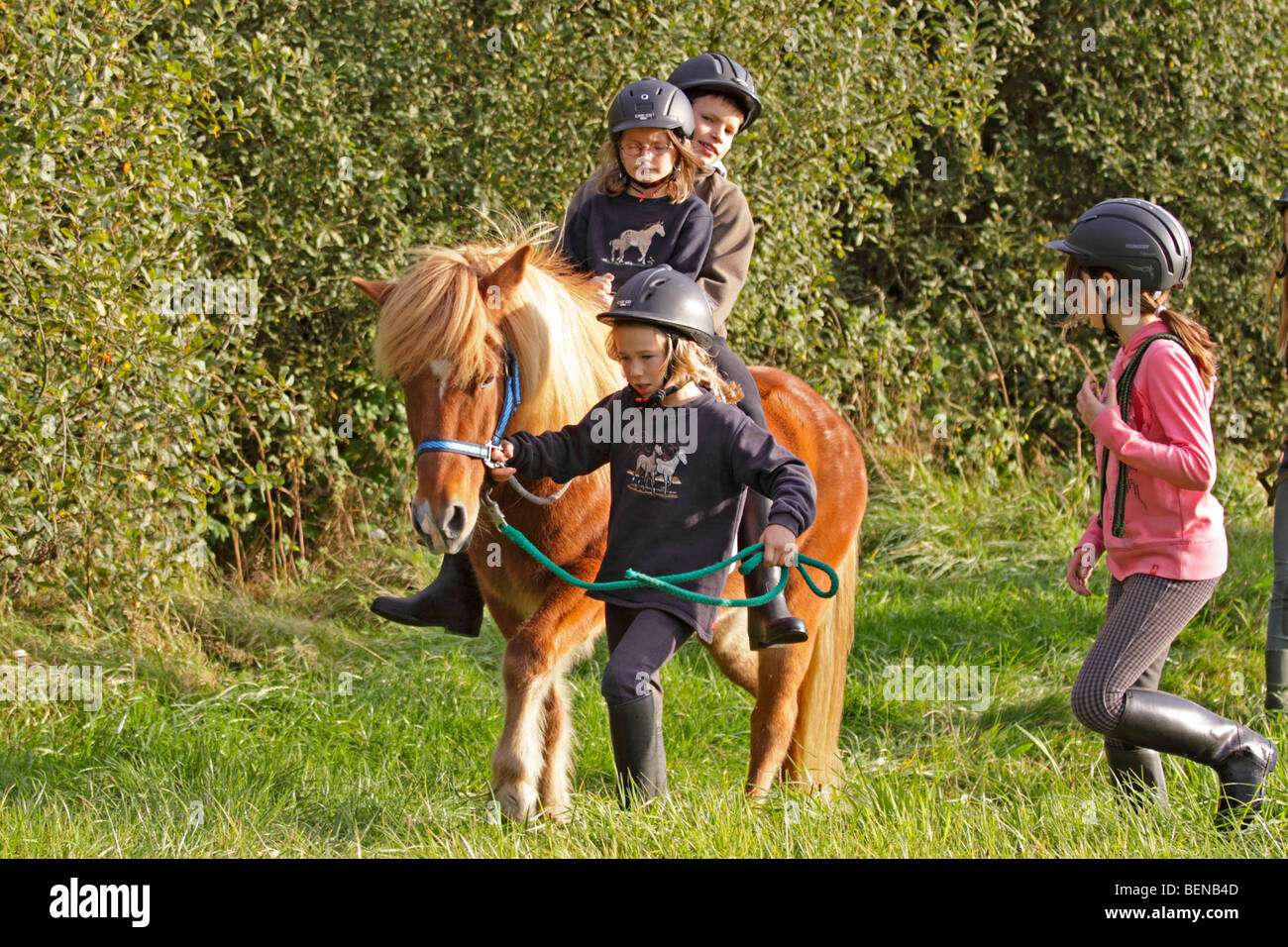 Bambini equitazione sulla loro pony attraverso una foresta Foto Stock