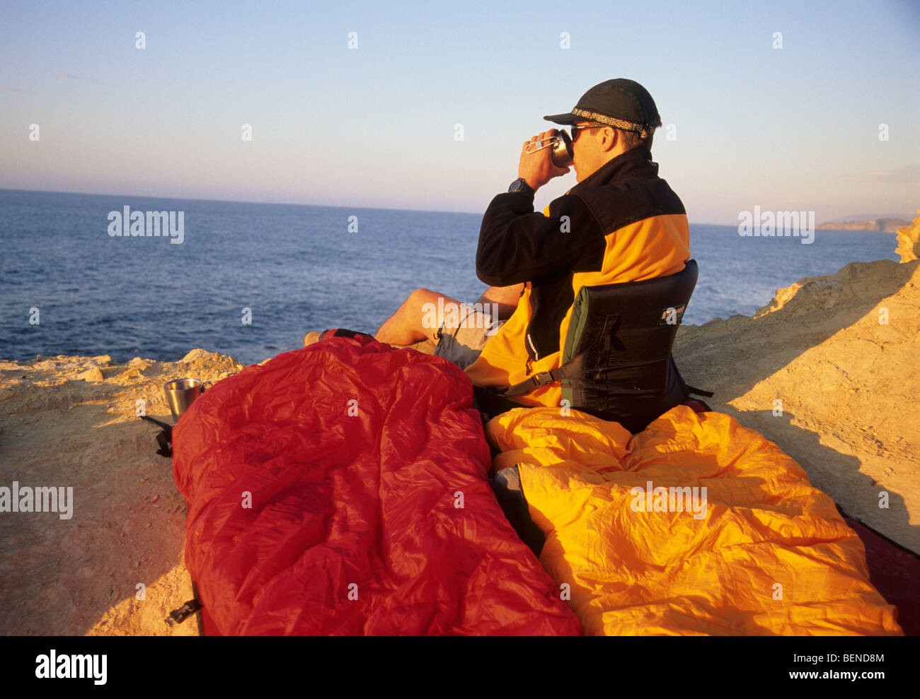 L'uomo godendo la vista dell'oceano mentre camping. Foto Stock