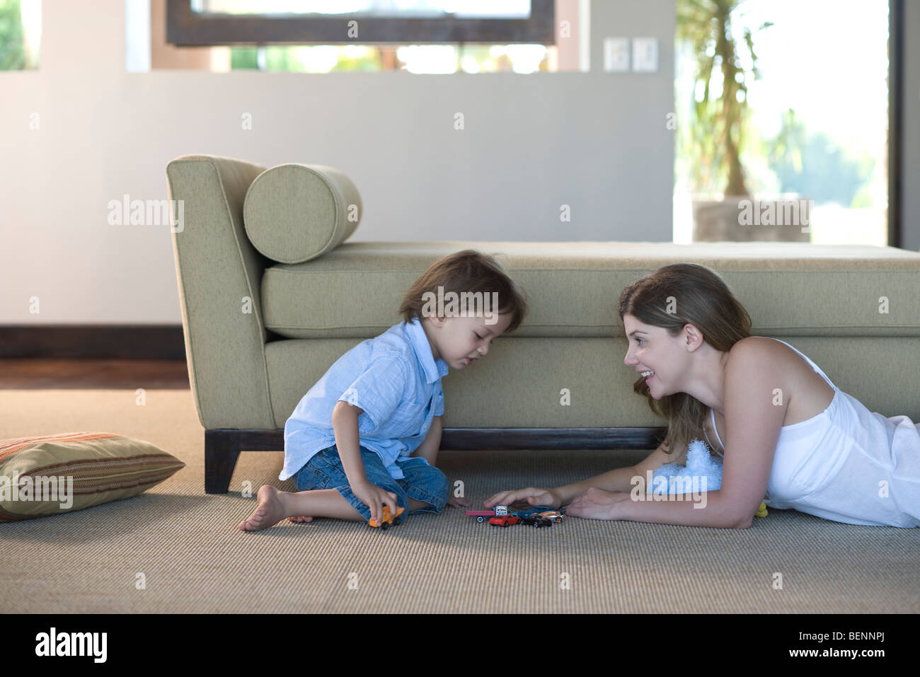 La madre e il bambino che gioca con automobili giocattolo Foto Stock